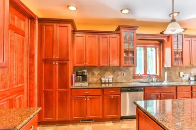 a kitchen with wooden cabinets and granite counter tops at Catskills retreat - ATV, Hot tub, hiking, fishing in Cairo