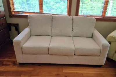a couch sitting in a living room with two windows at Catskills retreat - ATV, Hot tub, hiking, fishing in Cairo