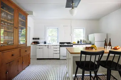 a kitchen with white cabinets and a table and chairs at 7 Mi to Belleayre Ski Mountain Getaway with Porch in Fleischmanns