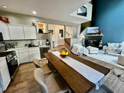 a kitchen and living room with a wooden table in a room at Windham Ridge Chalet in Windham