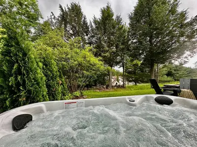 a bath tub sitting in a yard with trees at Windham Ridge Chalet in Windham