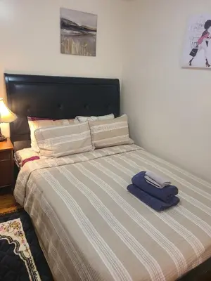 a bed with two towels sitting on top of it at Amazing family house in Newark