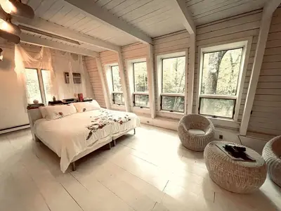 a bedroom with a bed in a room with windows at Peaceful Tree House Nestled Away in Hudson Valley, New York in Carmel Park Estates