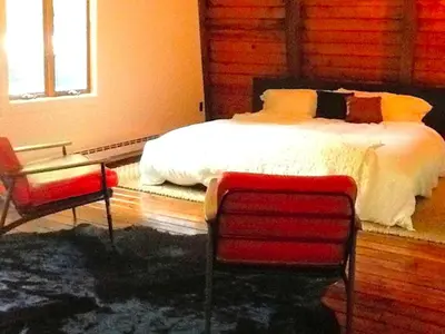 a bedroom with a bed and two chairs at Peaceful Tree House Nestled Away in Hudson Valley, New York in Carmel Park Estates