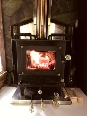a stove with a fire in a room at Romantic Glamping Getaway in a Pet Friendly Caravan, Ideal to Explore Hudson Valley in New Forge