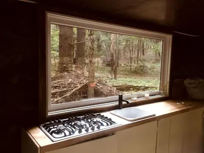 a kitchen window with a stove and a sink at Romantic Glamping Getaway in a Pet Friendly Caravan, Ideal to Explore Hudson Valley in New Forge