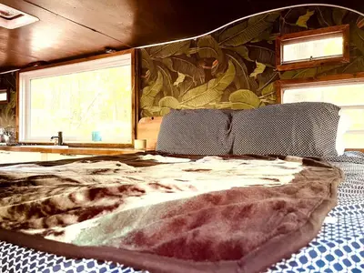 a bedroom with a large bed in front of a mural at Romantic Glamping Getaway in a Pet Friendly Caravan, Ideal to Explore Hudson Valley in New Forge