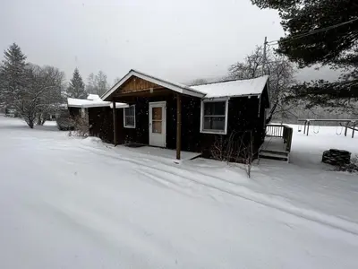 a small house is covered in snow at Homey Pet-Friendly Cabin Rental for Groups in the Catskills in Big Indian