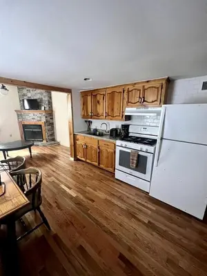 a kitchen with white appliances and a wooden floor at Homey Pet-Friendly Cabin Rental for Groups in the Catskills in Big Indian