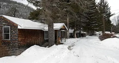 a house with snow on the ground next to a house at Homey Pet-Friendly Cabin Rental for Groups in the Catskills in Big Indian