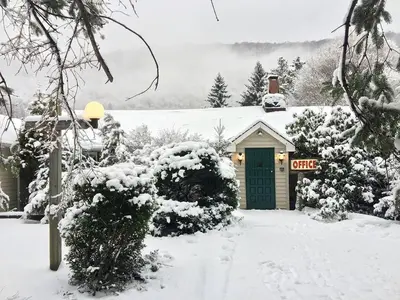 a house with a green door in the snow at Homey Pet-Friendly Cabin Rental for Groups in the Catskills in Big Indian