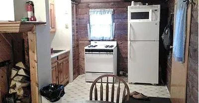 a kitchen with a stove and a white refrigerator at Simple Cabin Camping for Families in the Catskills of Upstate New York in Big Indian
