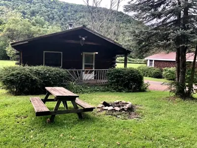 a picnic table sitting in front of a cabin at Simple Cabin Camping for Families in the Catskills of Upstate New York in Big Indian