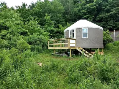 a yurt in the middle of a field with trees at Beautiful Yurt with Breathtaking Views in Livingston Manor, New York in Livingston Manor