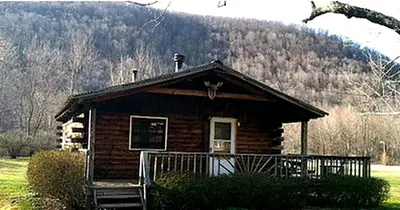 a small log cabin with a mountain in the background at Rustic Cabin Rental for Groups near Woodstock, Upstate New York in Big Indian