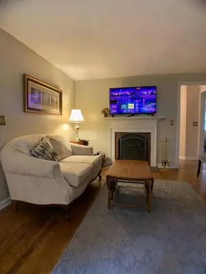 a living room with a couch and a tv above a fireplace at Peaceful and Pet-Friendly Cottage Rental on Picturesque Country Estate near Black Rock State Park, Connecticut in Watertown