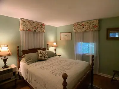 a bedroom with a bed and a window with curtains at Peaceful and Pet-Friendly Cottage Rental on Picturesque Country Estate near Black Rock State Park, Connecticut in Watertown