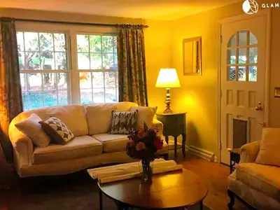 a living room with a couch and a table at Peaceful and Pet-Friendly Cottage Rental on Picturesque Country Estate near Black Rock State Park, Connecticut in Watertown