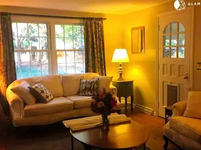 a living room with a couch and a table at Peaceful and Pet-Friendly Cottage Rental on Picturesque Country Estate near Black Rock State Park, Connecticut in Watertown
