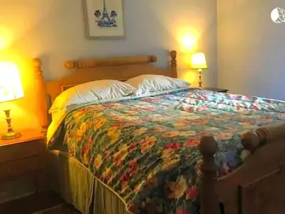 a bedroom with a bed with a colorful quilt and two lamps at Peaceful and Pet-Friendly Cottage Rental on Picturesque Country Estate near Black Rock State Park, Connecticut in Watertown