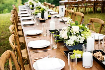 a long table with white plates and flowers on it at Luxurious Modern Chalet Rental on Top of the Shawangunk Mountains in New York in Cragsmoor
