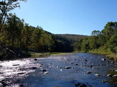 a river with rocks in the middle of it at Charming Cabin Getaway with a Wood-Burning Stove in Chesterfield, Massachusetts in Chesterfield