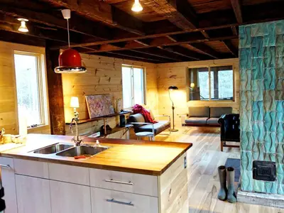 a kitchen with a sink and a living room at Charming Cabin Getaway with a Wood-Burning Stove in Chesterfield, Massachusetts in Chesterfield