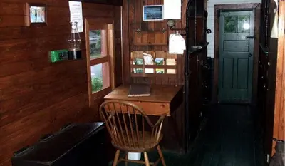 a desk in a room with a chair and a door at Vintage Caboose Rental in Historic Small Town near Springfield, Massachusetts in Chester