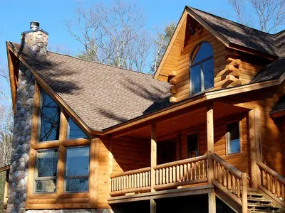 a wooden house with a porch and a roof at Rustic Log Cabin in the Catskills, Upstate New York in Olivebridge