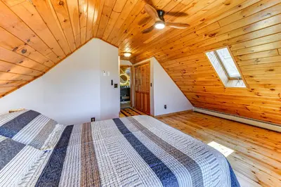a bedroom with a bed in a wooden ceiling at West Branch Delaware River Cozy Cabin Retreat! in Deposit