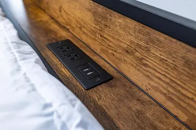 a black remote control sitting on top of a bed at Hudson Haven-Near NYC Transit in West New York