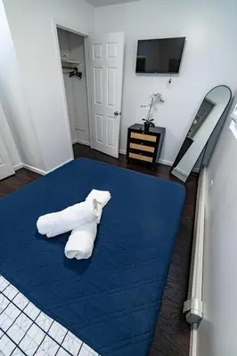 a room with a blue bed with towels on it at Hudson Haven-Near NYC Transit in West New York
