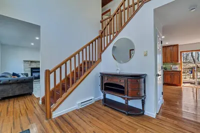 a living room with a staircase and a mirror on a table at Home in Bushkill Saw Creek Poconos area in Saw Creek