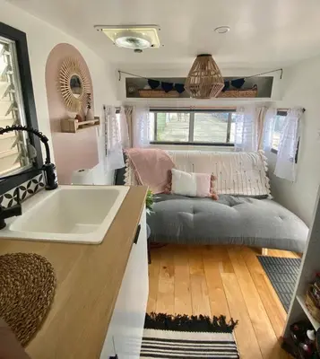 a bathroom with a tub and a couch and a sink at Vintage Shasta Camper for the best of NYC Glamping in Livingston Manor