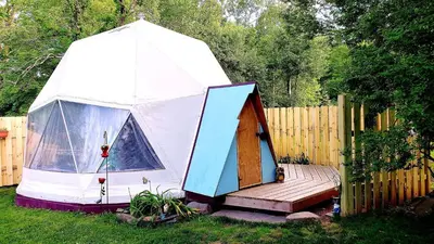 a tent with a wooden deck in a yard at Romantic Glamping Dome in the Catskill Mountains near Woodstock, New York in Hensonville