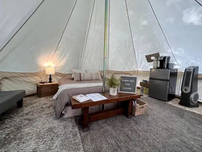 a bedroom in a tent with a bed and a table at Lovely Bell Tent for Memorable Glamping Weekends in Conneticut