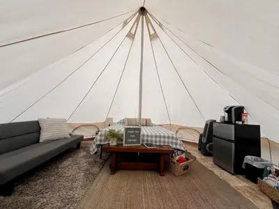 a living room with a tent with a couch and a table at Lovely Bell Tent for Memorable Glamping Weekends in Conneticut