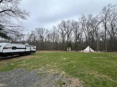 an rv parked in a field next to a tent at Lovely Bell Tent for Memorable Glamping Weekends in Conneticut