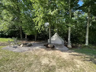 a white tent sitting in the middle of a forest at Lovely Bell Tent for Memorable Glamping Weekends in Conneticut