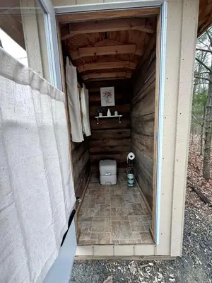 a bathroom with a toilet in a wooden house at Lovely Bell Tent for Memorable Glamping Weekends in Conneticut