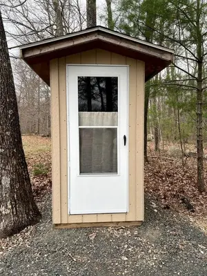 a doghouse with a white door in the woods at Lovely Bell Tent for Memorable Glamping Weekends in Conneticut