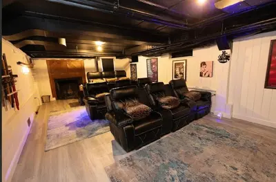 a living room with black leather furniture and a fireplace at Luxury Estate Elegant Private The White Lion Manor in Middletown