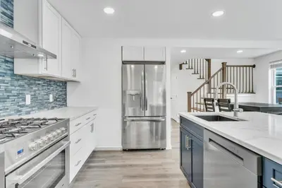 a kitchen with a stainless steel refrigerator and a staircase at Connecticut Waterfront Home, With Hot Tub, Cozy in Rocky Hill