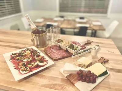 a table with two plates of food and a bottle of wine at Romantic Chalet Hot Tub Near Hunter Mountain in Tannersville
