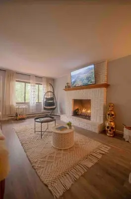 a living room with a fireplace and a tv at Romantic Chalet Hot Tub Near Hunter Mountain in Tannersville