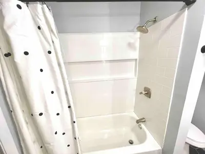 a bathroom with a shower with a white shower curtain at Romantic Chalet Hot Tub Near Hunter Mountain in Tannersville