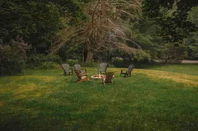 a group of chairs sitting around a table in the grass at Romantic Chalet Hot Tub Near Hunter Mountain in Tannersville
