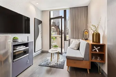 a living room with a tv and a couch and a chair at The Vibe on 5th Vibe 8750 in New York