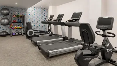 a gym with several cardio machines in a room at The Vibe on 5th XIII Vibe 8762 in New York