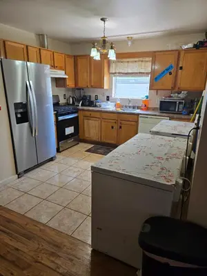 a kitchen with wooden cabinets and a refrigerator at Gold queen 4A in Newark